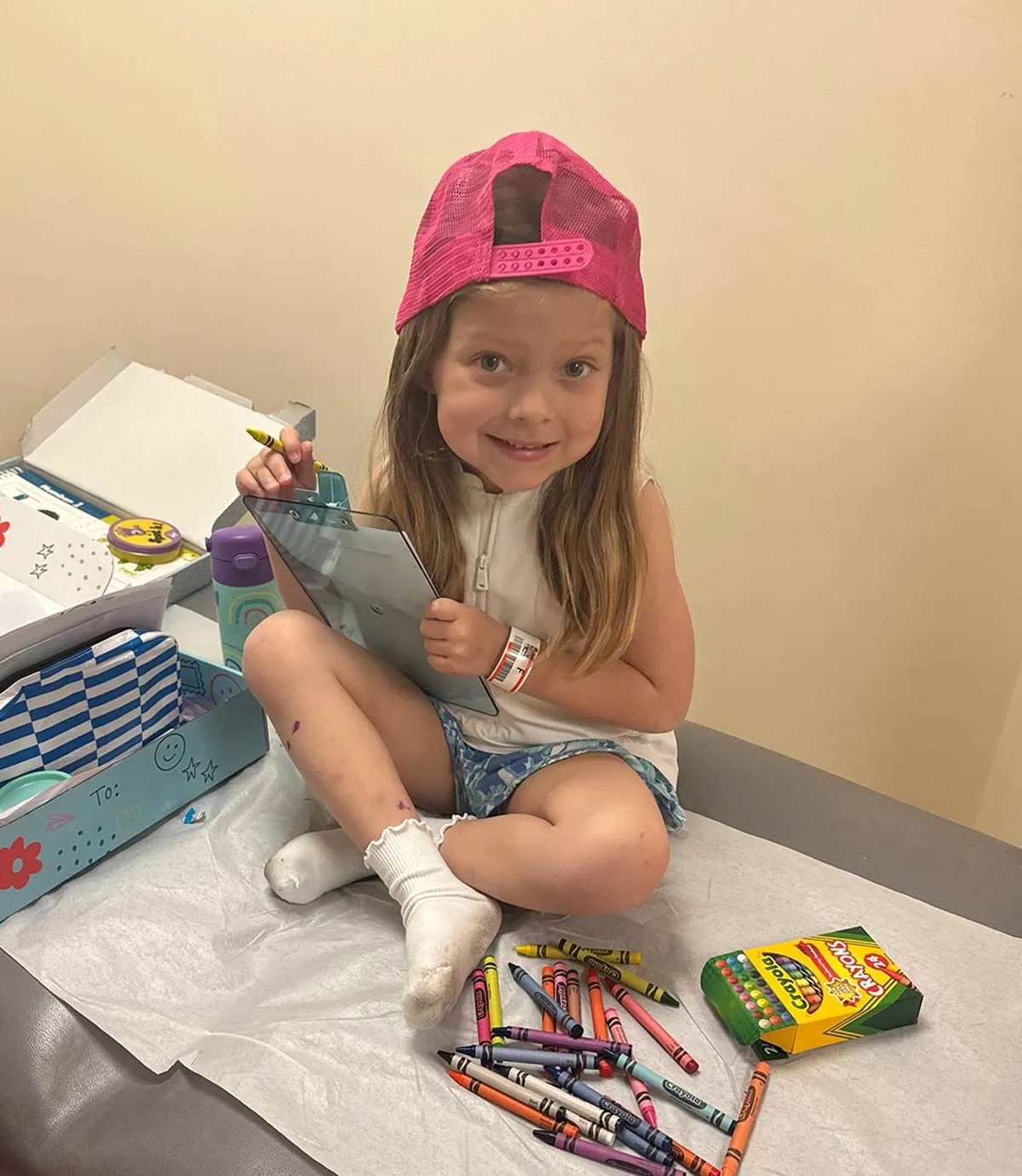 Child doing crafts with Boombox supplies on a hospital bed