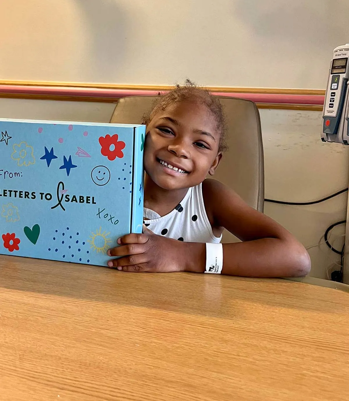 Smiling child holding their Boombox in the hospital