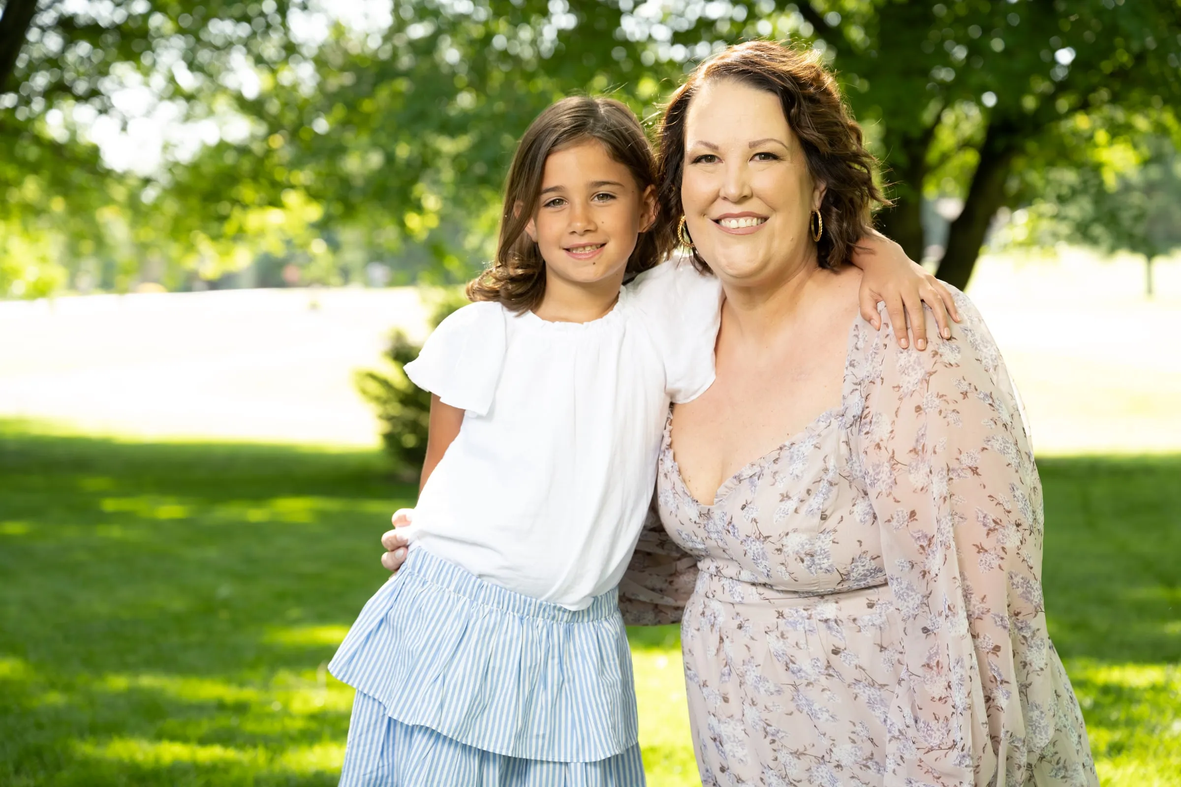 A young club member and her mom smiling together outdoors