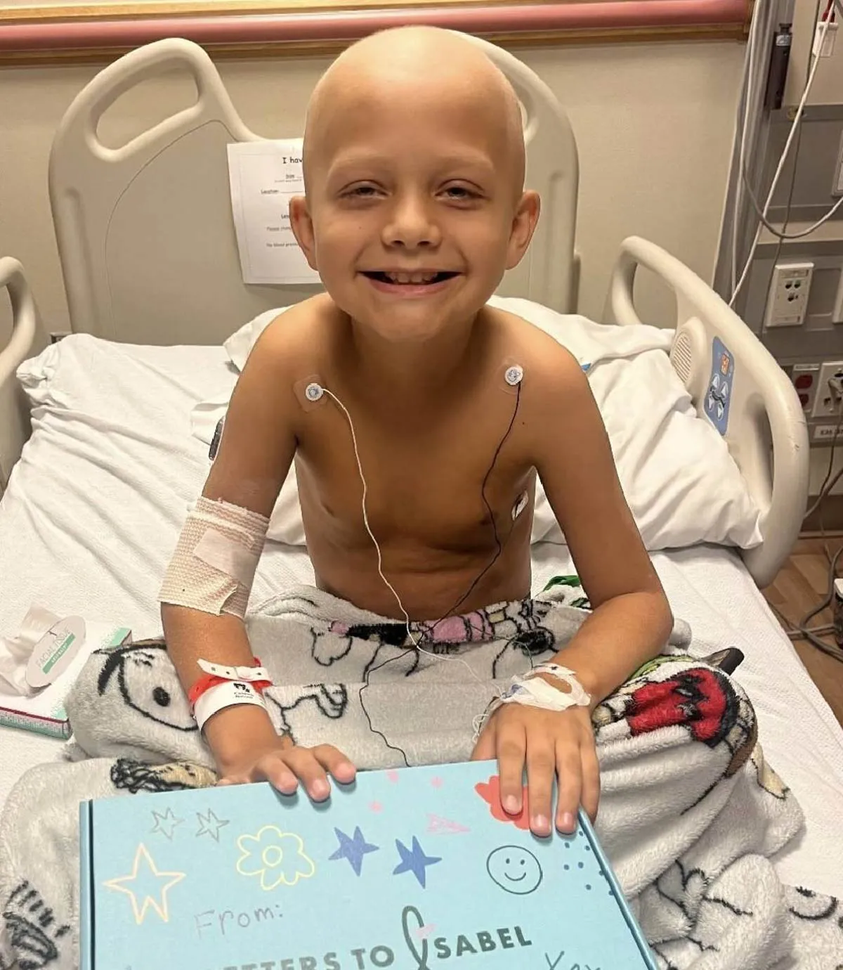Child in a hospital bed opening a Boombox