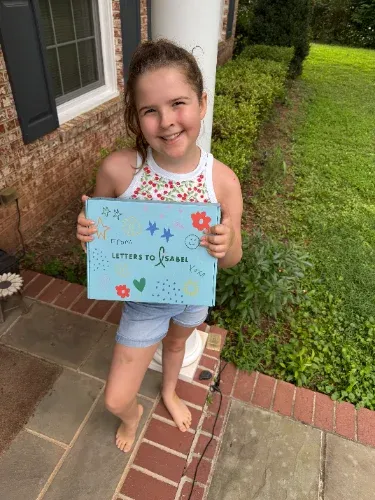 Club member holding her Letters to Isabel Boombox